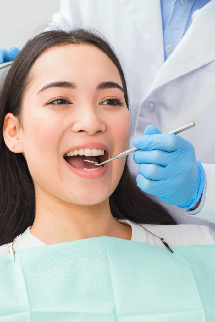 Young asian woman smiling while getting a dental exam.